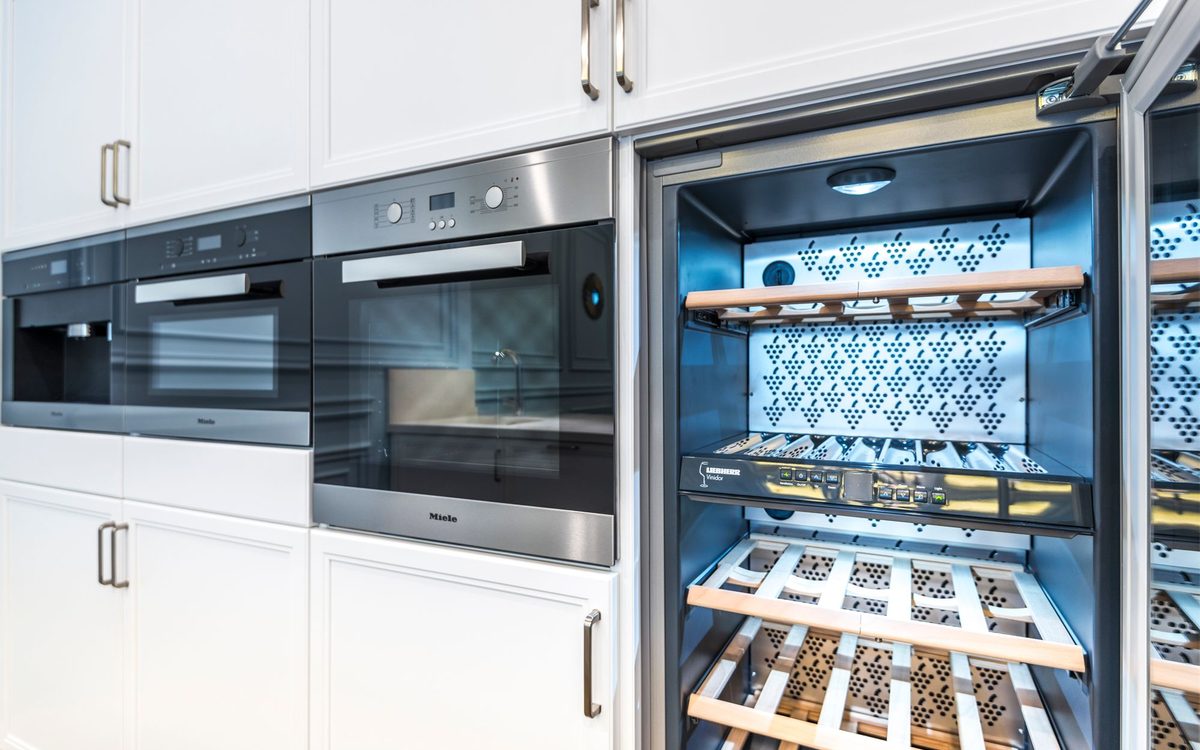 Elegant modern kitchen featuring built-in ovens and a wine cooler with stylish cabinetry.